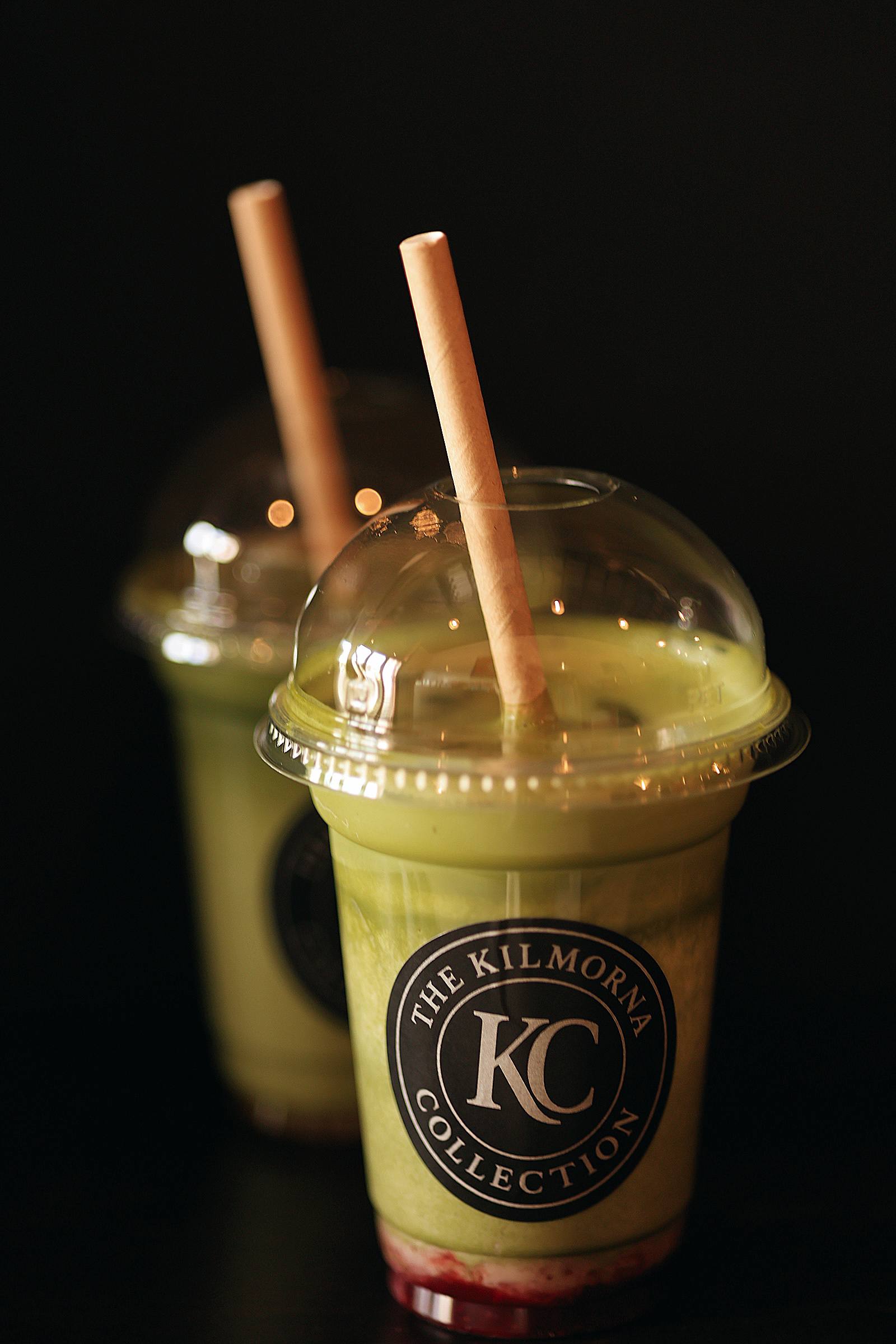 Two cold green matcha drinks in Kilmorna Collection cups with red fruit at the bottom