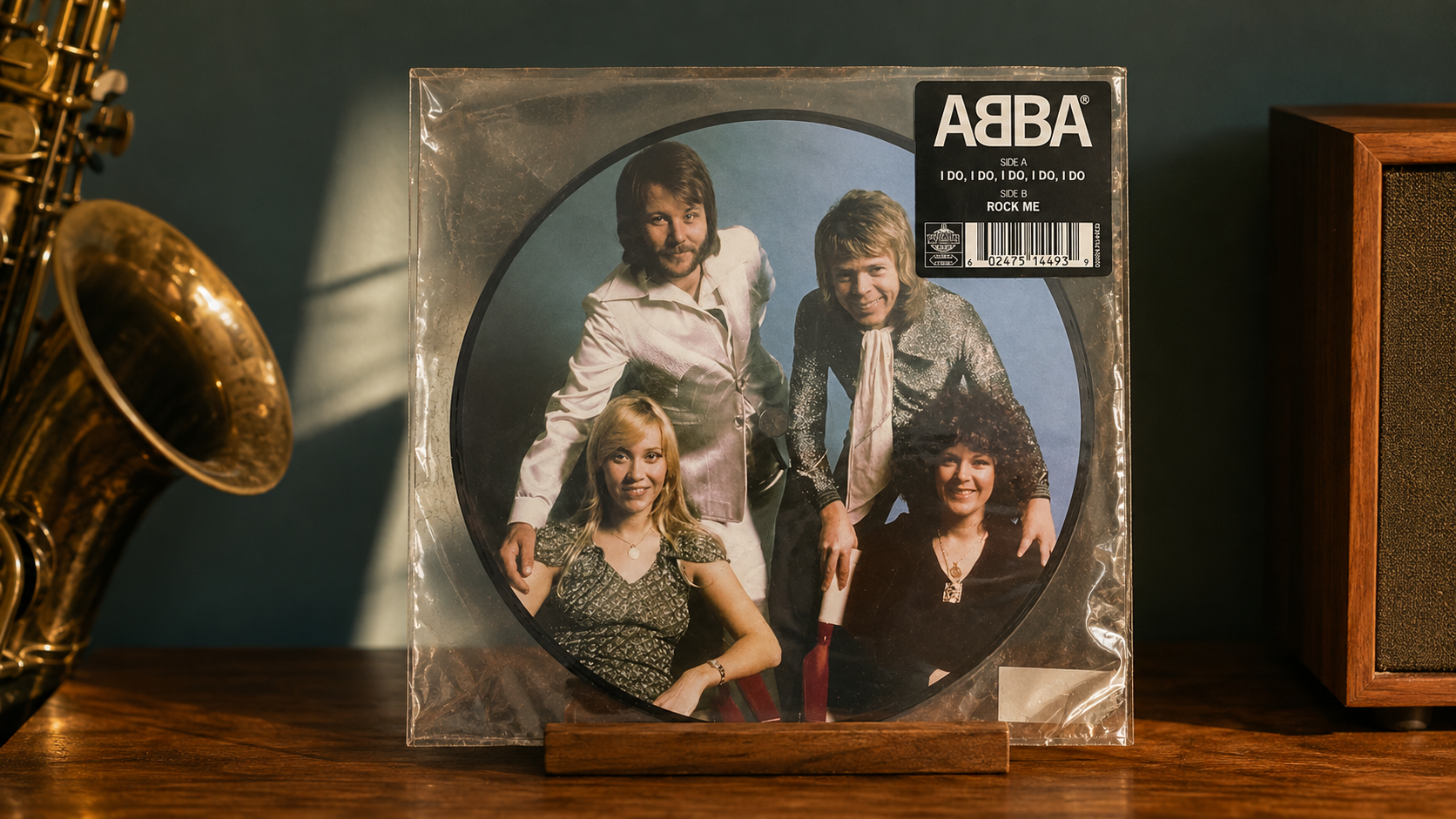 ABBA I Do, I Do, I Do, I Do, I Do / Rock Me vinyl picture disc in its clear sleeve on a walnut stand beside a saxophone