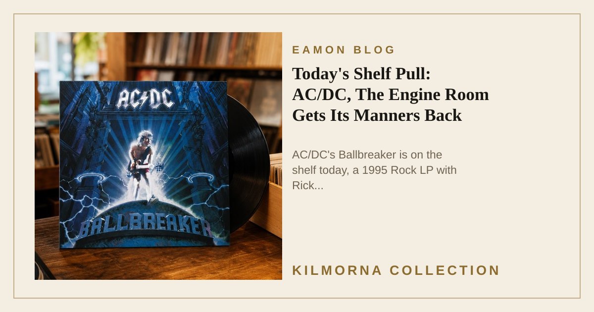 AC/DC Ballbreaker LP sleeve standing on a warm wooden record shop counter beside a turntable and vinyl racks.
