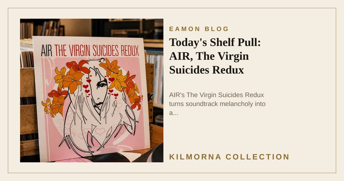 AIR The Virgin Suicides Redux LP sleeve standing on a warm record shop counter beside a vinyl record and turntable.