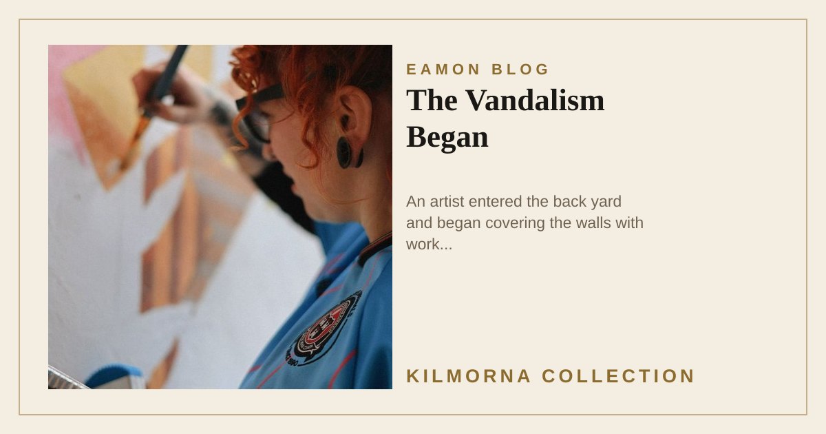 Artist painting a mural in the back yard of The Kilmorna Collection